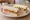 Sandwich Traiteur: an illustration of ham, salmon, butter, cream cheese and more on white bread.