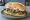 Sándwich Tucumano: an illustration of beef, lettuce, tomato, egg and more on baguette.