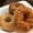 Three bagels stacked on a white plate: one plain, one everything-seeded, one topped with baked cheese.