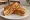 Schezwan Sandwich: an illustration of butter, cucumber, tomato, onion and more on white bread.