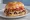 Schmitter: an illustration of beef, salami, cheese, tomato and more on kaiser roll.