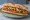 Schnitzel b'Baguette (שניצל בבאגט): an illustration of chicken and olive oil on baguette.