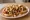 Scrambled Dog: an illustration of hot dog, pepper, onion, pickle and more on hot dog bun.