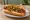Seattle Dog: an illustration of hot dog, cream cheese, onion, sriracha and more on hot dog bun.