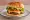 Shake Shack ShackBurger: an illustration of beef, american cheese, lettuce, tomato and more on burger bun.