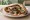 Shawarma Bakar (שווארמה בקר): an illustration of beef, tahini, tomato, cucumber and more on pita.