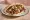 Shawarma Keves (שווארמה כבש): an illustration of lamb, tahini, tomato, cucumber and more on pita.