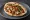 Shawarma Of (שווארמה עוף): an illustration of chicken, tahini, hummus, tomato and more on pita.