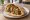 Shishlik Of (שישליק עוף): an illustration of chicken, onion, tomato, parsley and more on pita.