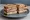 Sloppy Joe (NJ Style): an illustration of turkey, ham, beef, swiss cheese and more on rye bread.