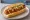 Sosisli Sandviç: an illustration of sausage, ketchup, mustard, pickle and more on bread.