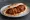 Soutzoukakia se Pita (Σουτζουκάκια): an illustration of beef, marinara, cumin, garlic and more on pita.