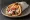 Souvlaki Hirino se Pita: an illustration of pork, tzatziki, tomato, onion and more on pita.