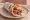 Souvlaki (Thessaloniki Usage): an illustration of pork, tzatziki, tomato, onion and more on pita.