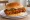 Spicy Chicken Sandwich: an illustration of chicken, hot sauce, cayenne, pickle and more on burger bun.