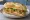 Suprema: an illustration of chicken, egg, lettuce, tomato and more on baguette.