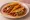 Taco de Canasta de Adobo: an illustration of pork, onion and salsa on tortilla.