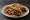 Taco de Canasta de Mole: an illustration of chicken, brown sauce and onion on tortilla.