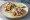 Taco de Ceviche: an illustration of fish, shrimp, lime, tomato and more on tortilla.