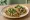Taco de Chicharrón en Salsa Verde: an illustration of salsa verde, onion and cilantro on tortilla.