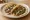 Taco de Frijoles: an illustration of beans, onion, cilantro and salsa on tortilla.