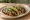 Taco de Mole: an illustration of chicken, brown sauce, onion and cilantro on tortilla.