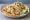 Taco de Pescado: an illustration of fish, cabbage, sour cream, salsa and more on tortilla.
