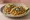 Taco de Pollo Desmenuzado: an illustration of chicken, salsa, onion, cilantro and more on tortilla.