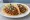 Taco de Ropa Vieja: an illustration of beef, tomato, onion, bell pepper and more on tortilla.