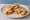 Taco Gobernador de Camarón: an illustration of shrimp, cheese, onion and tomato on tortilla.