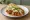 Taco Placero: an illustration of cabbage, onion, queso fresco, avocado and more on tortilla.