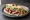 Tandoori Chicken Sandwich: an illustration of chicken, yogurt, onion, cucumber and more on white bread.