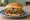 Tavern Sandwich: an illustration of beef, onion, mustard, pickle and more on white bread.