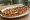 Tavuklu Pide: an illustration of chicken, onion, parsley and cheese on pita.