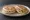 Tigelle con Pesto Modenese: an illustration of garlic and rosemary.