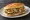 Torta: an illustration of beans, avocado, sour cream, lettuce and more on bread.