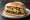 Torta de Arrachera: an illustration of refried beans, avocado, lettuce, tomato and more on bread.
