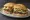 Torta de Bistec: an illustration of beef, onion, refried beans, avocado and more on bread.