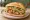 Torta de Camarón: an illustration of shrimp, refried beans, avocado, lettuce and more on bread.
