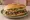 Torta de Carne Asada: an illustration of beef, refried beans, avocado, lettuce and more on bread.