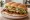 Torta de Cecina Enchilada: an illustration of beef, refried beans, avocado, lettuce and more on bread.