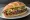 Torta de Cecina: an illustration of beef, refried beans, avocado, lettuce and more on bread.