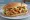 Torta de Chicharrón: an illustration of refried beans, avocado, lettuce, tomato and more on bread.