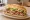 Torta de Pierna: an illustration of pork, refried beans, avocado, lettuce and more on bread.