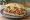 Torta de Salchicha: an illustration of hot dog, beans, sour cream, avocado and more on bread.