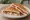 Tostado de Jamón Crudo y Queso: an illustration of cheese on white bread.