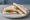 Tramezzino alla Caprese: an illustration of mozzarella, tomato, basil and olive oil on white bread.