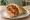 Trapizzino con Pollo alla Cacciatora: an illustration of chicken, tomato, rosemary and garlic.