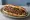 Urfa Ekmek Arası: an illustration of lamb, onion, parsley and sumac on bread.