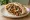 Vegan Shawarma (שווארמה טבעונית): an illustration of mock meat, mushroom, tahini, tomato and more on pita.